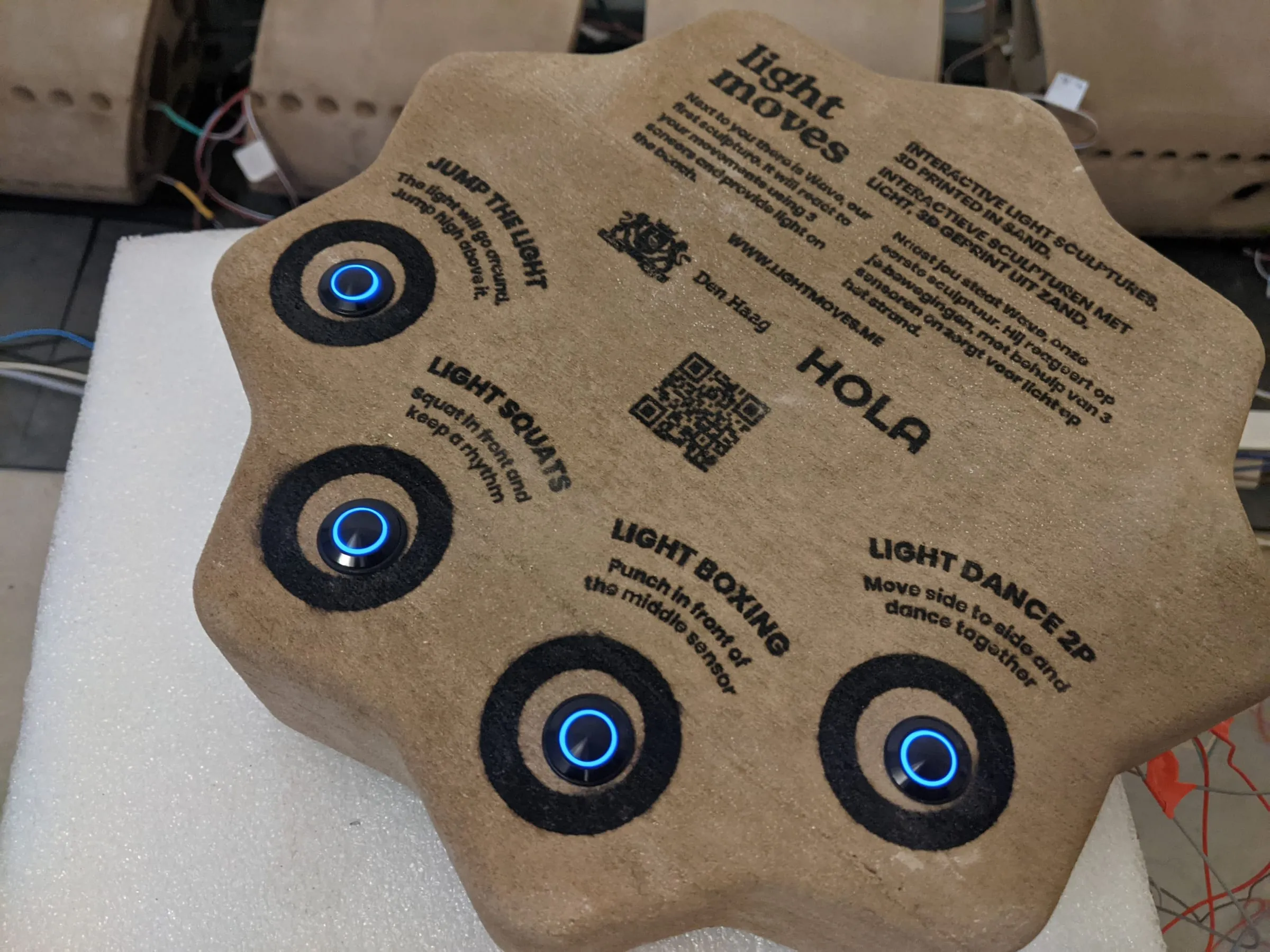 The sand-printed control post with four lit buttons and printed instructions