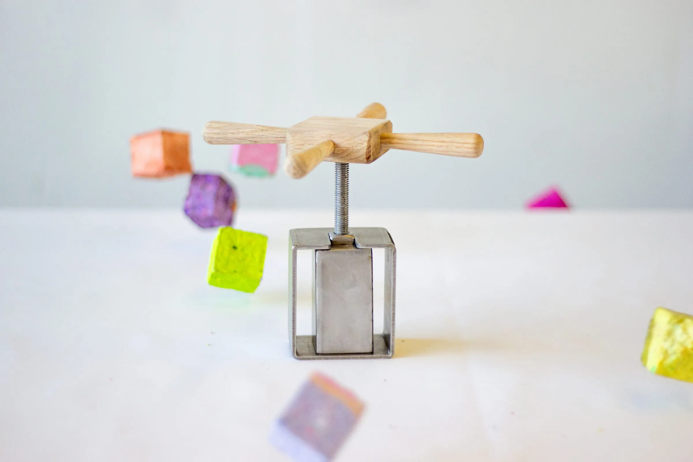 The Cubcho press in stainless steel and wood, with coloured blocks made from recycled paper