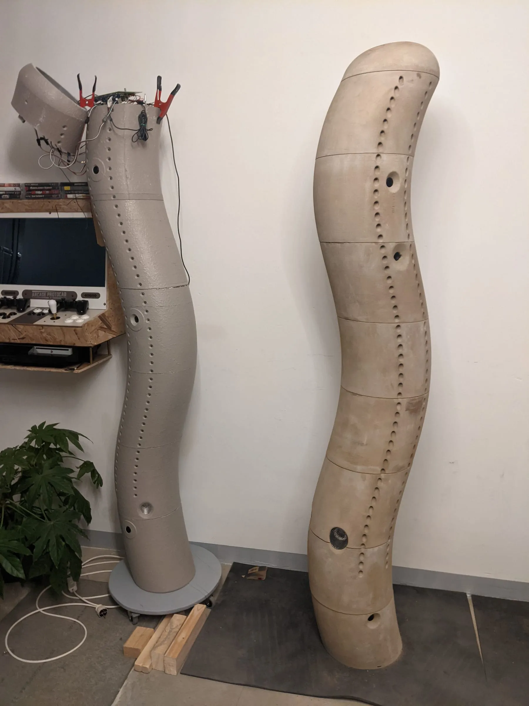 The grey prototype standing beside the finished sand-printed sculpture